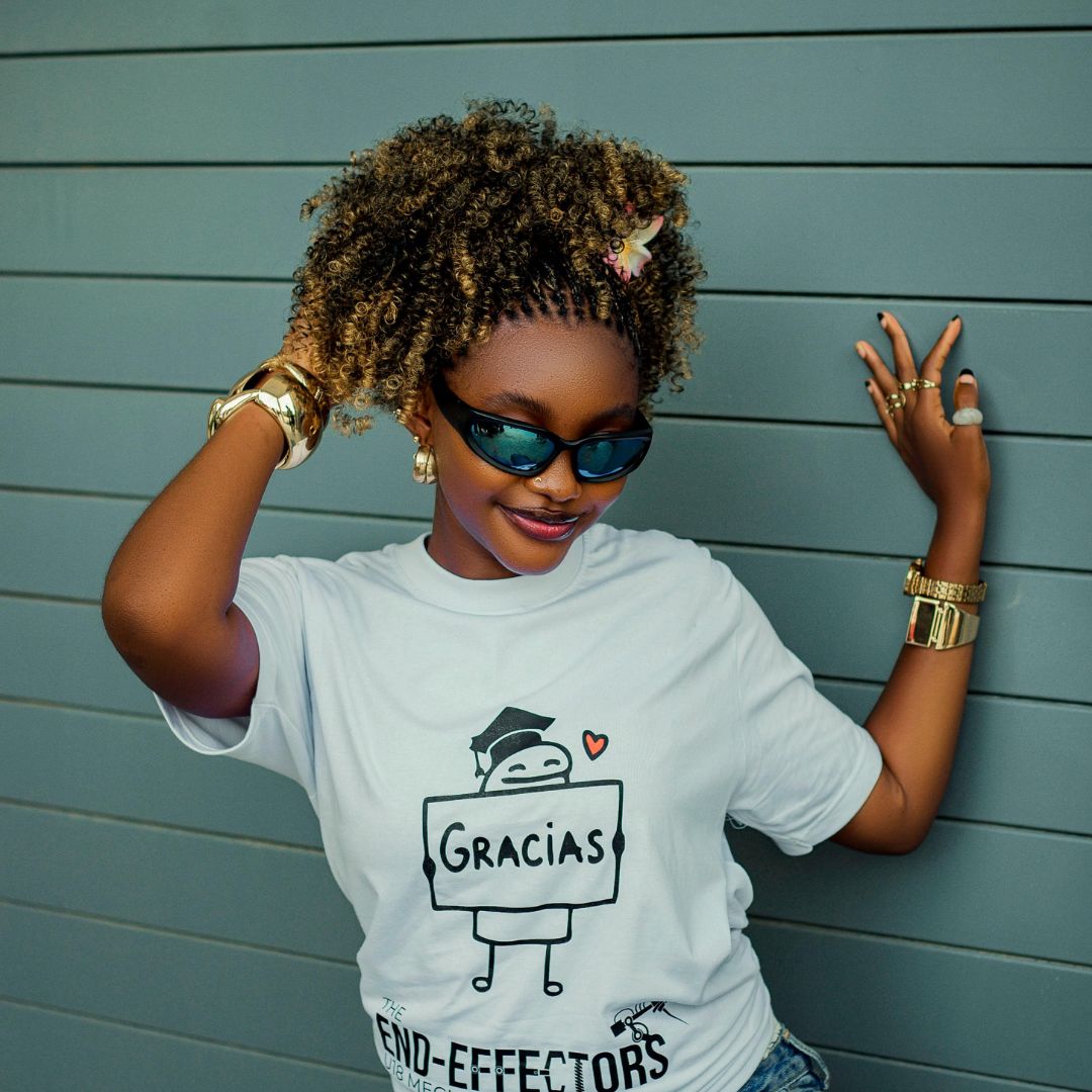 Model adjusting sunglasses while wearing a mint T-shirt.