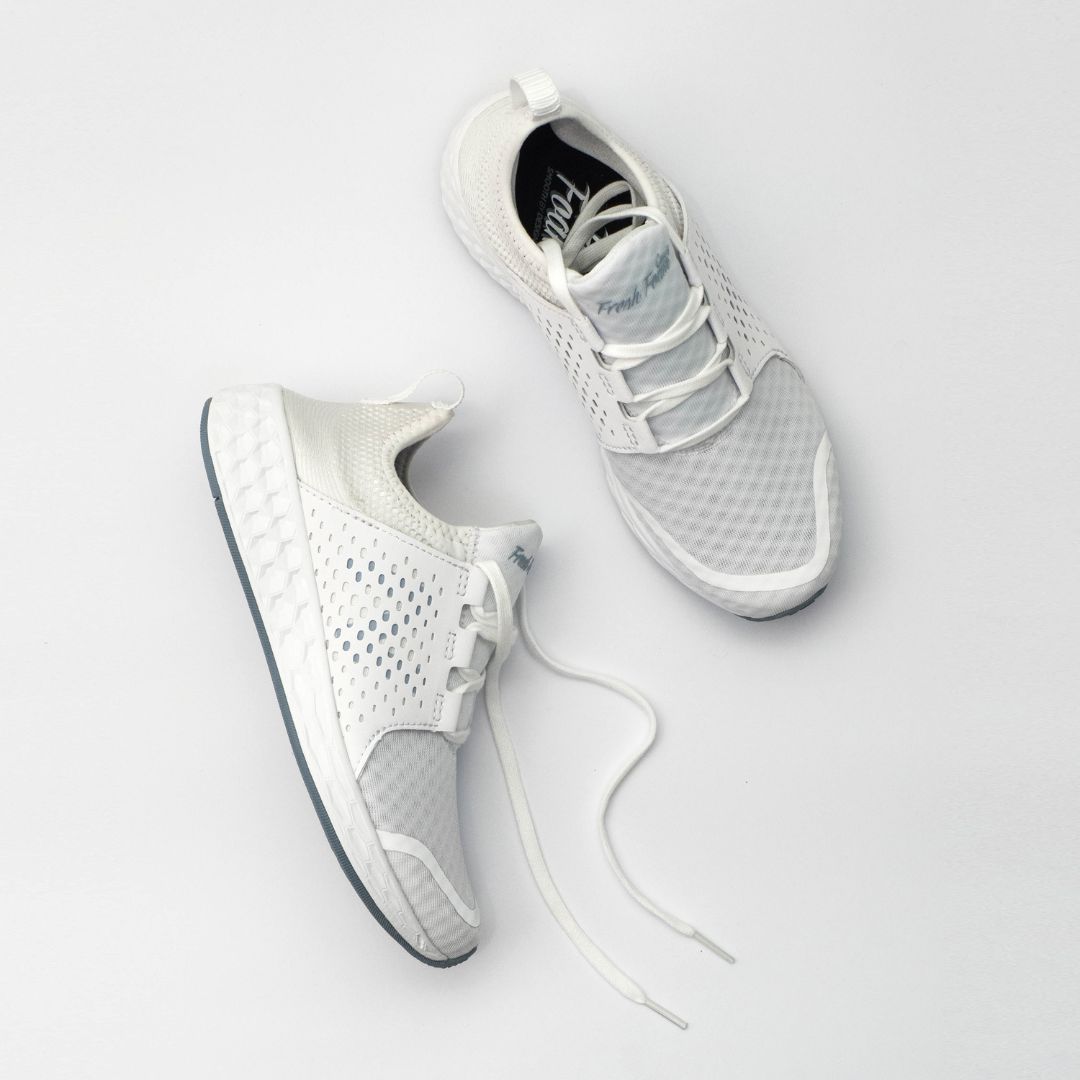 White sneakers photographed on a bright white set.