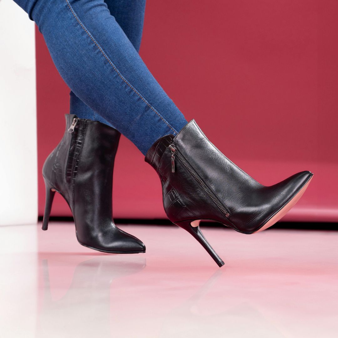 Red pointed high heels worn with blue pants.