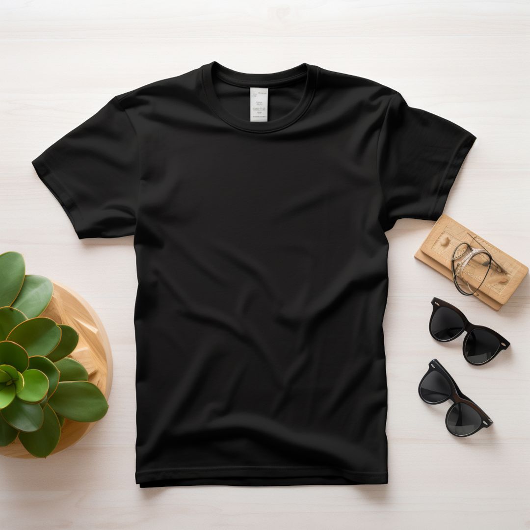 Black T-shirt laid flat on a styled background.
