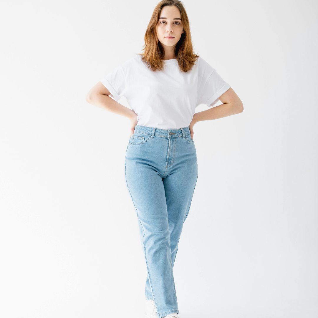 Woman wearing a relaxed white T-shirt and jeans.