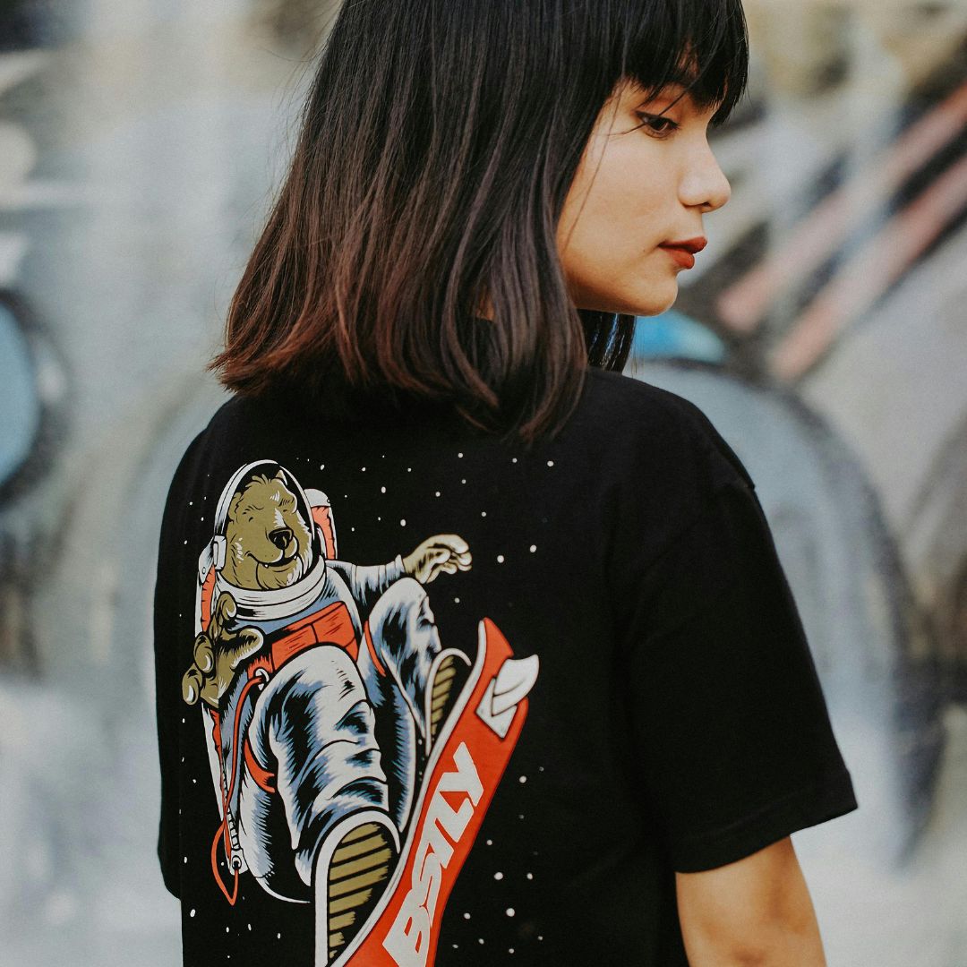 Black graphic T-shirt worn by a model outdoors.